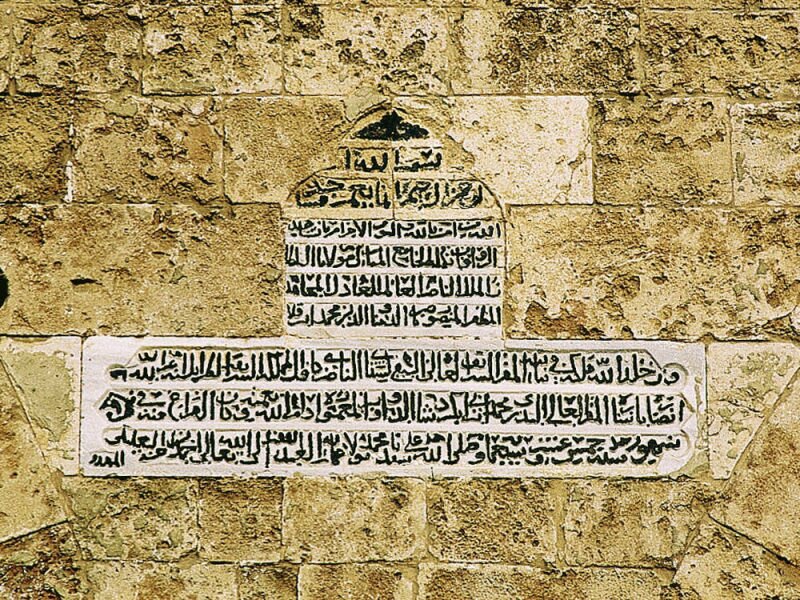 The inscription tablet on the eastern wall of the arcade refering to the completion of the Mansouri Great Mosque.